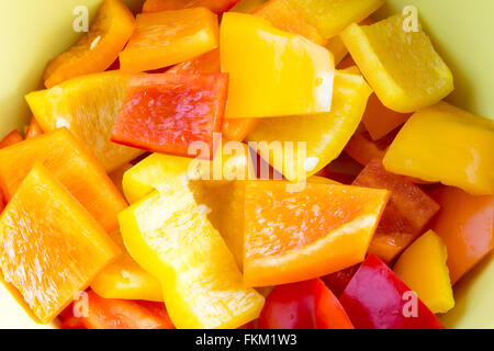 Piccolo peperone di pezzi in una ciotola in diversi colori, giallo, rosso e arancione Foto Stock