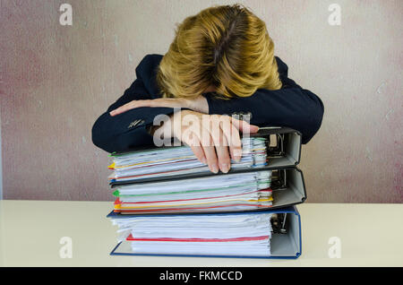 Stanco imprenditrice dorme sulla pila di cartelle Foto Stock