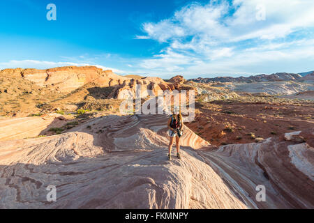 Tourist, escursionista presso l'onda di fuoco formazione di arenaria, dietro Sleeping Lizard formazione di roccia, la Valle del Fuoco del parco statale, Nevada Foto Stock