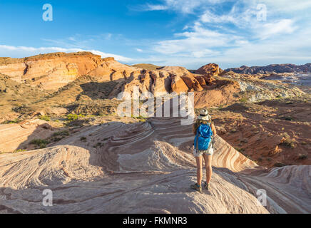 Tourist, escursionista presso l'onda di fuoco formazione di arenaria, dietro Sleeping Lizard formazione di roccia, la Valle del Fuoco del parco statale, Nevada Foto Stock