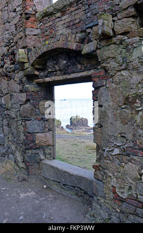 Una nave sul mare del Nord attraverso una finestra tra le rovine del castello di Slains, accanto a Cruden Bay, Aberdeenshire, Scozia, Foto Stock