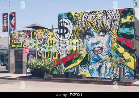 Una colorata carta murale sulla Melrose Avenue a Los Angeles, California raffigura una donna stilizzata con galleggianti di denaro attraverso il murale. Foto Stock