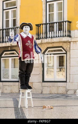 Un mimo in costume tradizionale di eseguire su una strada nel centro di Lisbona, Portogallo Foto Stock