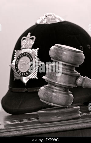 Concetto giuridico la Metropolitan Police casco con giudici martello a Londra tribunali situazione UK (B&W tonica) Foto Stock