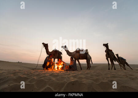 Commerciante di cammello nel deserto del Thar durante il sunrise. Deserto di Thar situato a Jaisalmer, Rajastan, Foto Stock