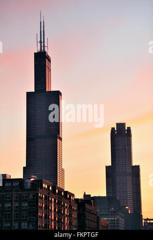 Chicago, Illinois, Stati Uniti d'America. Il sunrise come si riflette in ciuffi di nuvole e Chicago's Willis Tower (formerly Sears Tower) su un inverno mattina. Foto Stock