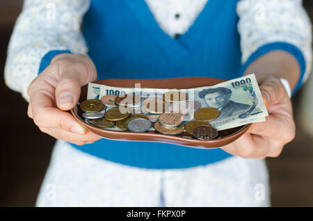 Yen giapponese note e monete giapponese sulla piastra Foto Stock