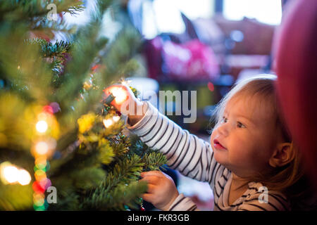 Ragazza caucasica decorare albero di Natale Foto Stock