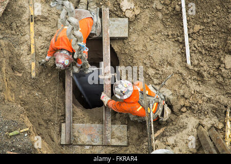 Lavoratori caucasici edificio al sito in costruzione Foto Stock