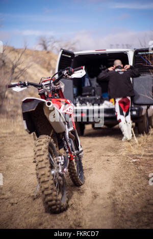 Chiusura del motociclo dietro dirt bike rider e van Foto Stock