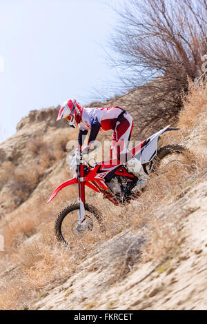 Equitazione per motociclisti dirt bike nel campo remoto Foto Stock