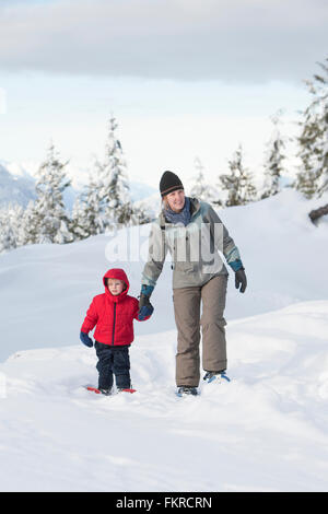 Caucasian madre e figlio a piedi nella neve Foto Stock