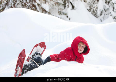 Ragazzo caucasico escursioni con le racchette da neve su pendio Foto Stock