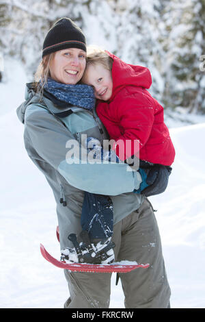 Caucasian madre e figlio di fare escursioni con le racchette da neve Foto Stock