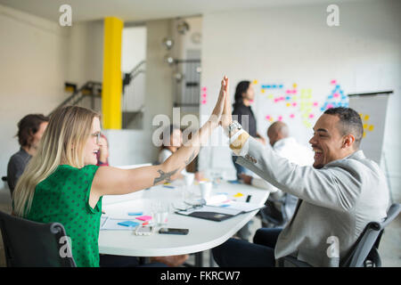 La gente di affari ad alta fiving in office meeting Foto Stock