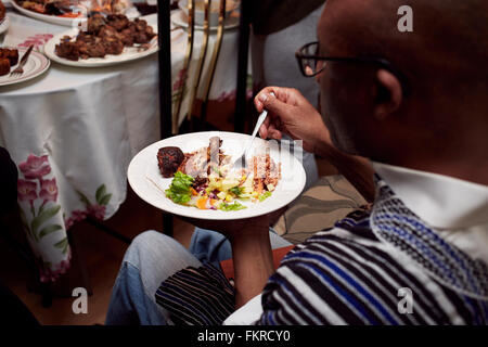 Elevato angolo di visione dell uomo nero di mangiare la cena Foto Stock