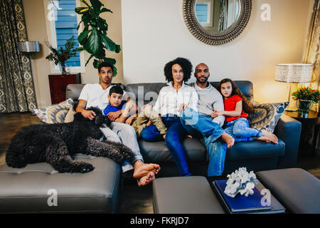 Famiglia di guardare la televisione sul divano Foto Stock