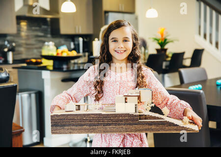 Razza mista ragazza con modello di casa Foto Stock