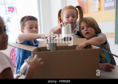 Gli studenti la donazione di conserve di merci in aula Foto Stock