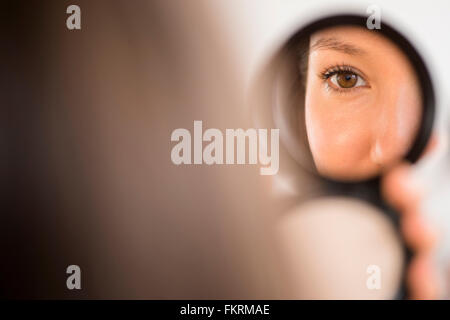 Razza mista donna ammirando se stessa in specchio compatto Foto Stock