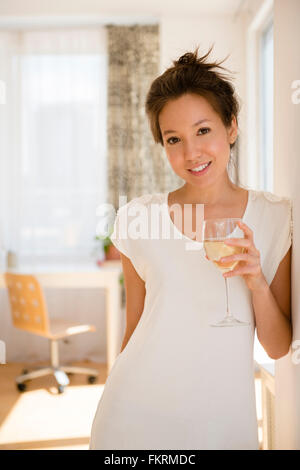 Razza mista donna bere il vino Foto Stock