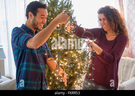 Giovane decorare albero di Natale Foto Stock