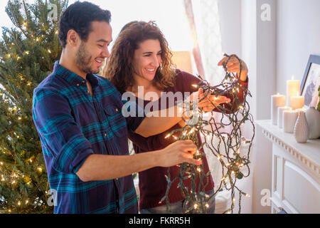 Giovane untangling le luci di Natale Foto Stock