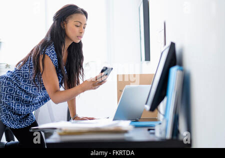 Razza mista imprenditrice tramite telefono cellulare Foto Stock