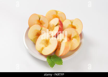 Piastra del dimezzato e seedless mele su sfondo bianco Foto Stock