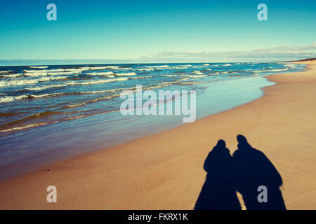 Ombra di un uomo e di una donna sulla spiaggia Foto Stock