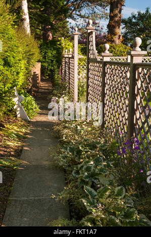 Sentiero ombreggiato, piante, trellis recinzione e scultura - progettato e paesaggistici, giardino soleggiato, Burley in Wharfedale, nello Yorkshire, Inghilterra. Foto Stock