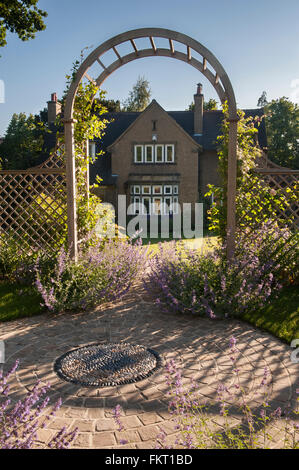 Vista attraverso il pergolato di arti e mestieri in casa progettata e paesaggistici, bellissimo giardino tradizionale, il Burley in Wharfedale, West Yorkshire, Inghilterra. Foto Stock