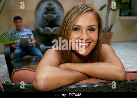 Donna seduta su un banco di lavoro in cortile Foto Stock