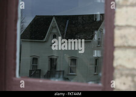 Vecchio creepy house di riflessione attraverso la finestra Foto Stock