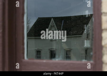 Vecchio creepy house di riflessione attraverso la finestra Foto Stock