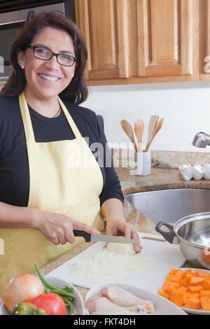 Donna ispanica la cottura in cucina Foto Stock