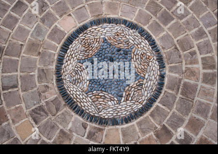 Colorate bande di pietra intorno a una circolare mosaico di ciottoli di artwork (close-up) - progettato e paesaggistici, giardino, Burley in Wharfedale, West Yorkshire, Inghilterra. Foto Stock