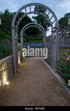 Vista del tramonto - tunnel illuminato arbor & transfrontaliera, recentemente progettato e paesaggistico giardino tradizionale, il Burley in Wharfedale, West Yorkshire, Inghilterra. Foto Stock