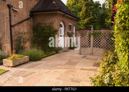 Progettato & paesaggistico giardino con patio pavimentato, schermata trellis & confine dal retro dell'entrata alle Arti & Mestieri style house - West Yorkshire, Inghilterra, Regno Unito. Foto Stock