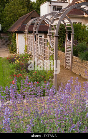 Recentemente progettata e paesaggistici, una bella e tradizionale giardino con pergolato e di frontiera in estate - Burley in Wharfedale, West Yorkshire, Inghilterra. Foto Stock