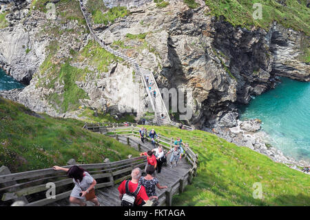 I turisti di affrontare i numerosi gradini costruiti intorno alle scogliere di Tintagel Castle, Tintagel, Cornwall, Regno Unito Foto Stock