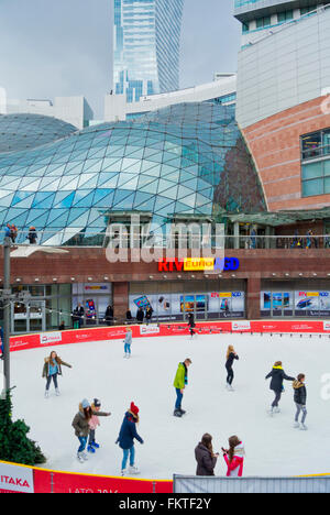 Pista di pattinaggio su ghiaccio, tra la stazione ferroviaria principale e Zlote Tarasy shopping mall, Varsavia, Polonia Foto Stock