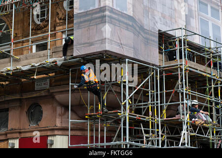 Operai erigere impalcature su un edificio nel quadrato di Leicester, nel West End di Londra, Regno Unito Foto Stock