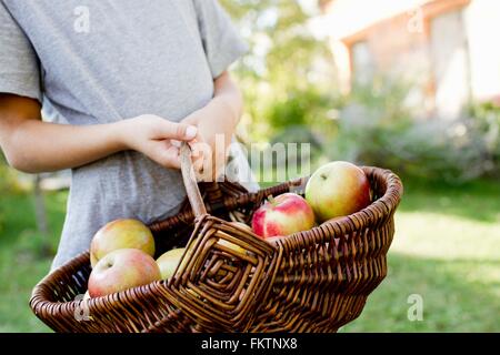 Ragazza con cesto di mele Foto Stock