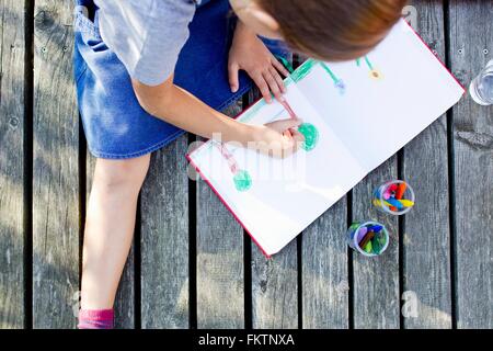 Ragazza foto di disegno nel notebook, angolo alto Foto Stock