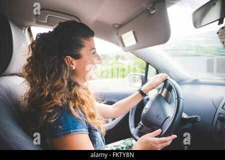 Felice donna alla guida di una vettura Foto Stock