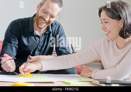 Uomo e donna che ride in riunione Foto Stock