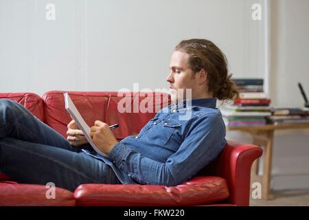 L'uomo scrivere note sul lettino Foto Stock