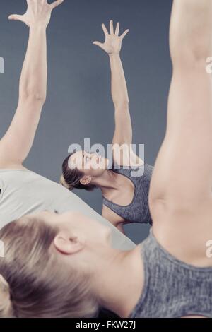 Le giovani donne a praticare yoga e sfondo grigio Foto Stock