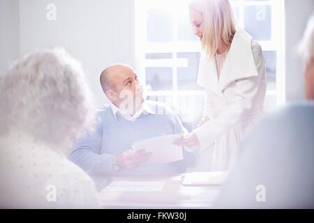 Segretario di consegnare la documentazione ai proprietari di office Foto Stock